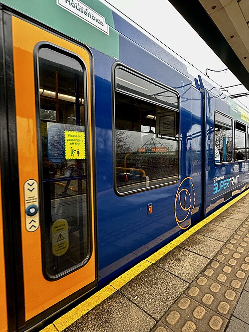 A blue and yellow Supertram waiting at the Meadowhall interchange.